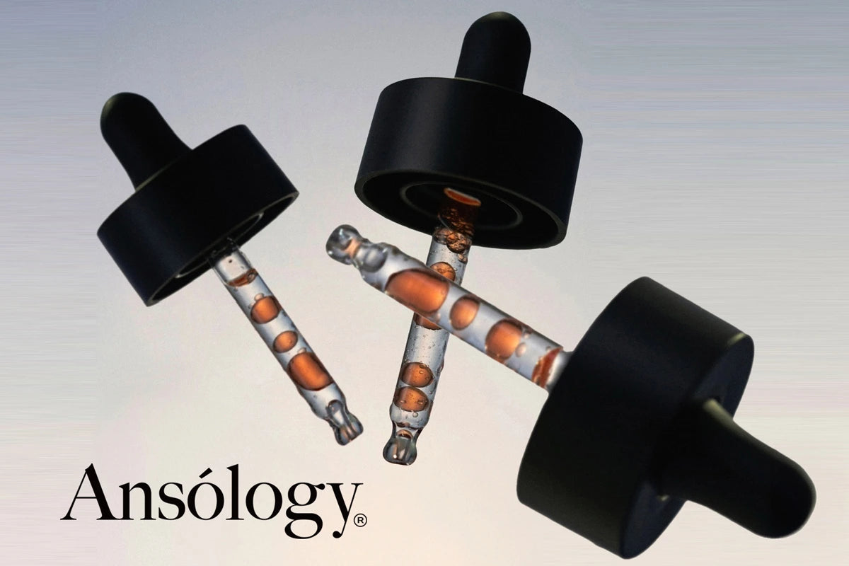 Sérum visage Ansólogy haut de gamme présenté dans trois pipettes en verre, texture fluide cosmétique transparente et capsules noires.